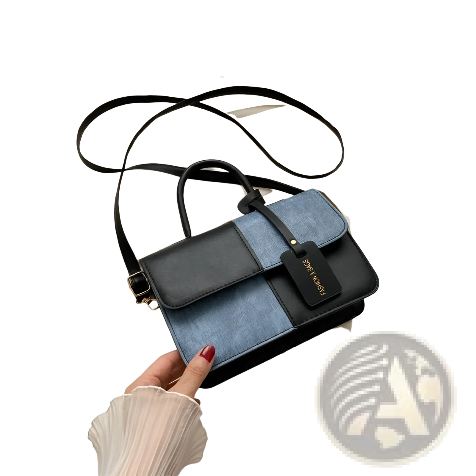 Two tone denim patchwork crossbody bag in black and blue with a sleek leather handle and adjustable strap