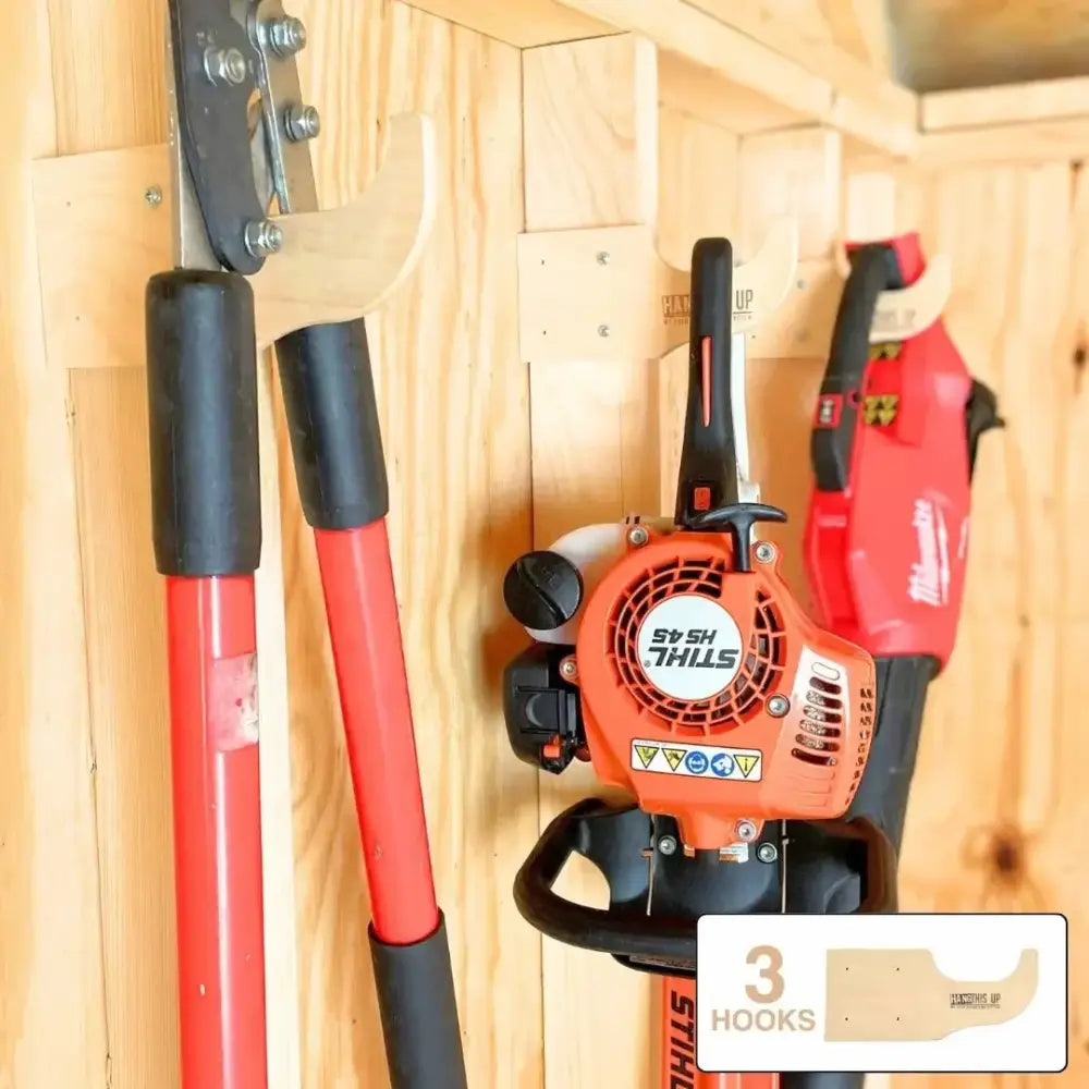 Orange and black stihl hs 45 hedge trimmer mounted on wooden wall organizer for garden tool storage and display
