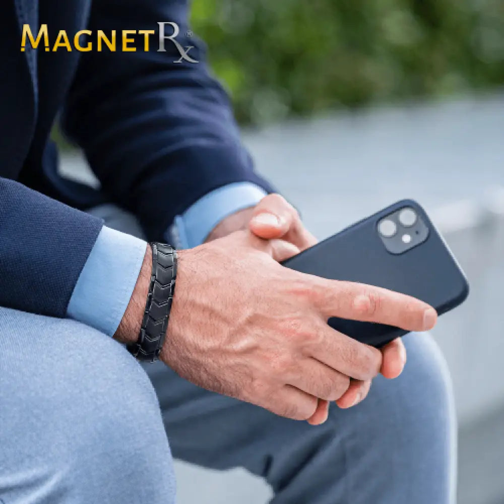 Black magnetic phone case with dual camera cutout shown on the back side held by a person in business attire