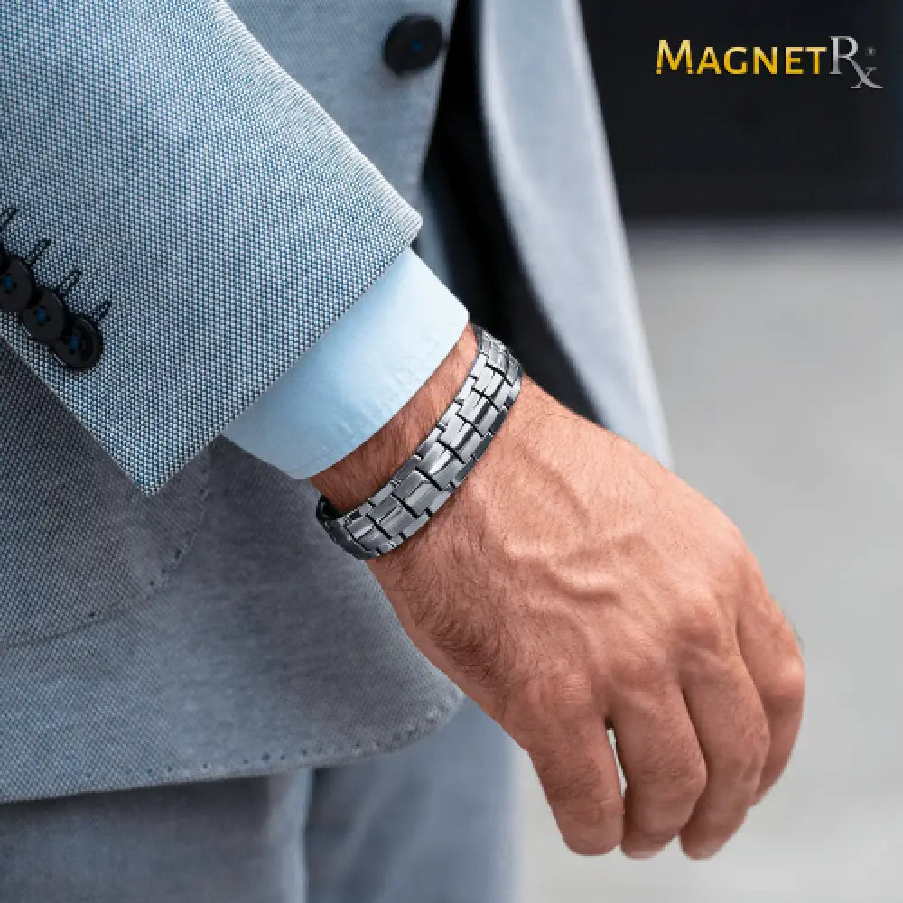 Silver metallic ultra strength magnetic stainless steel link bracelet with sleek modern design worn on man’s wrist