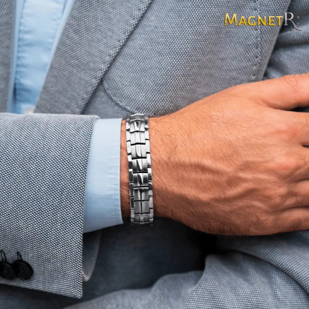 Ultra strength silver magnetic stainless steel link bracelet with sleek interlocking design worn on a man’s wrist