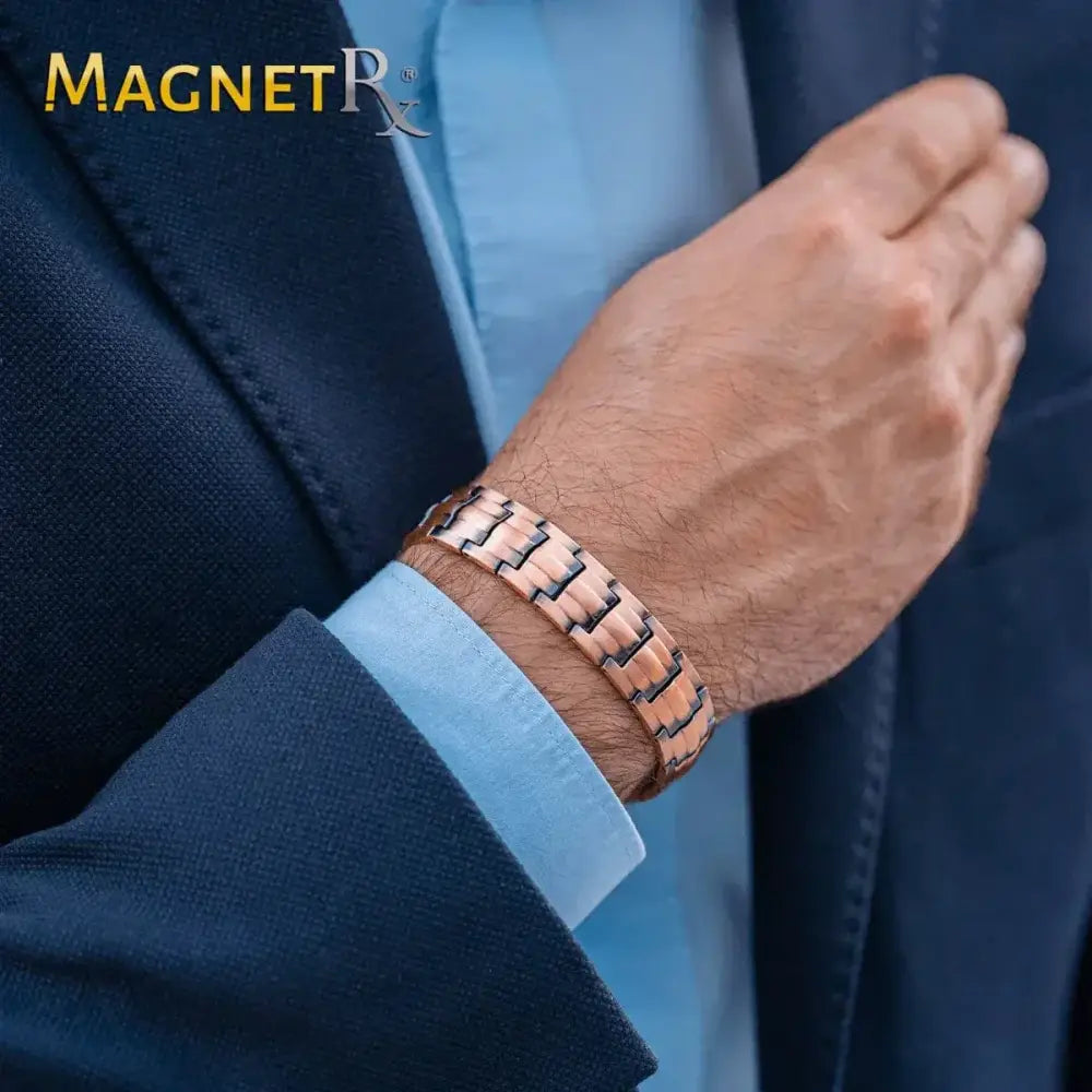 A sleek rose gold pure copper magnetic therapy bracelet with modern interlocking links worn on a mans wrist