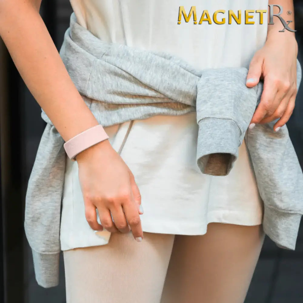 A soft pink silicone rose ultra strength magnetic therapy sports bracelet worn on the wrist for fitness tracking