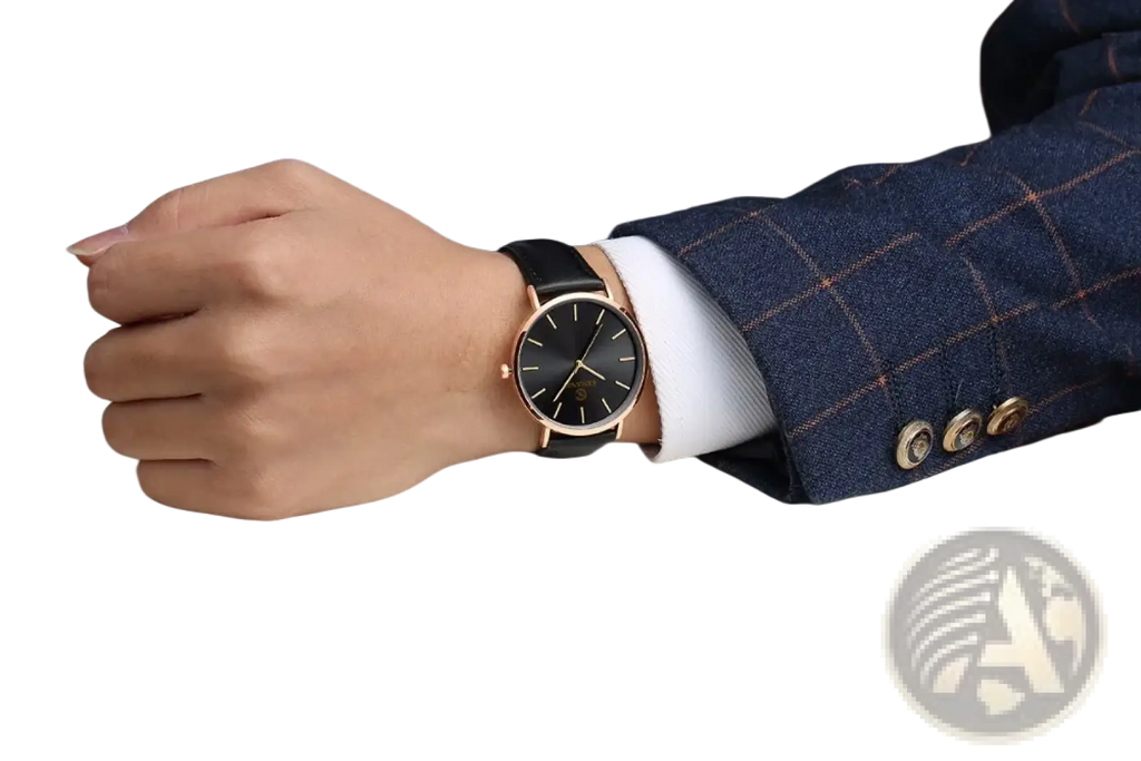 A sleek ultra thin gold mens leather quartz watch with black dial and rose gold case worn on a wrist in formal attire