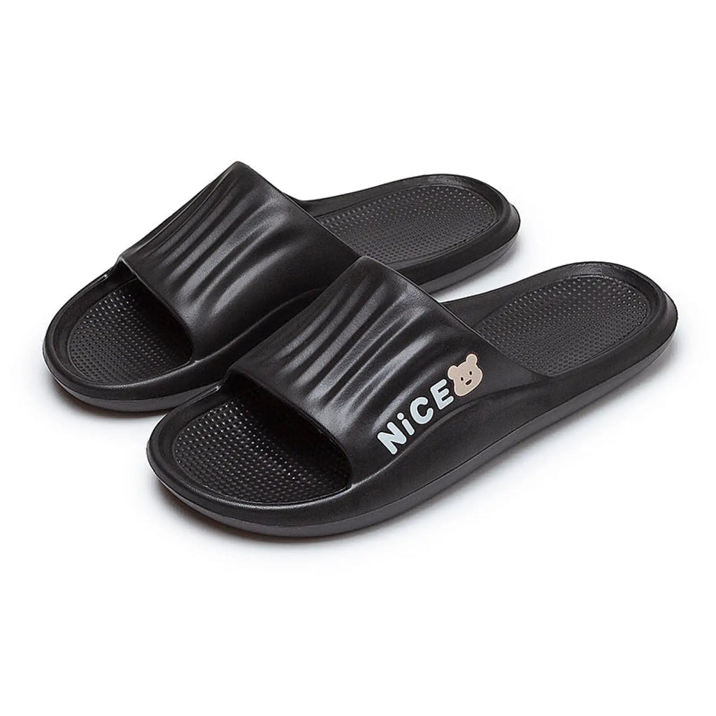 Black unisex lightweight anti slip EVA shower slides with ribbed strap featuring nice text and small bear logo