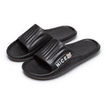 Black unisex lightweight anti slip EVA shower slides with ribbed strap featuring nice text and small bear logo