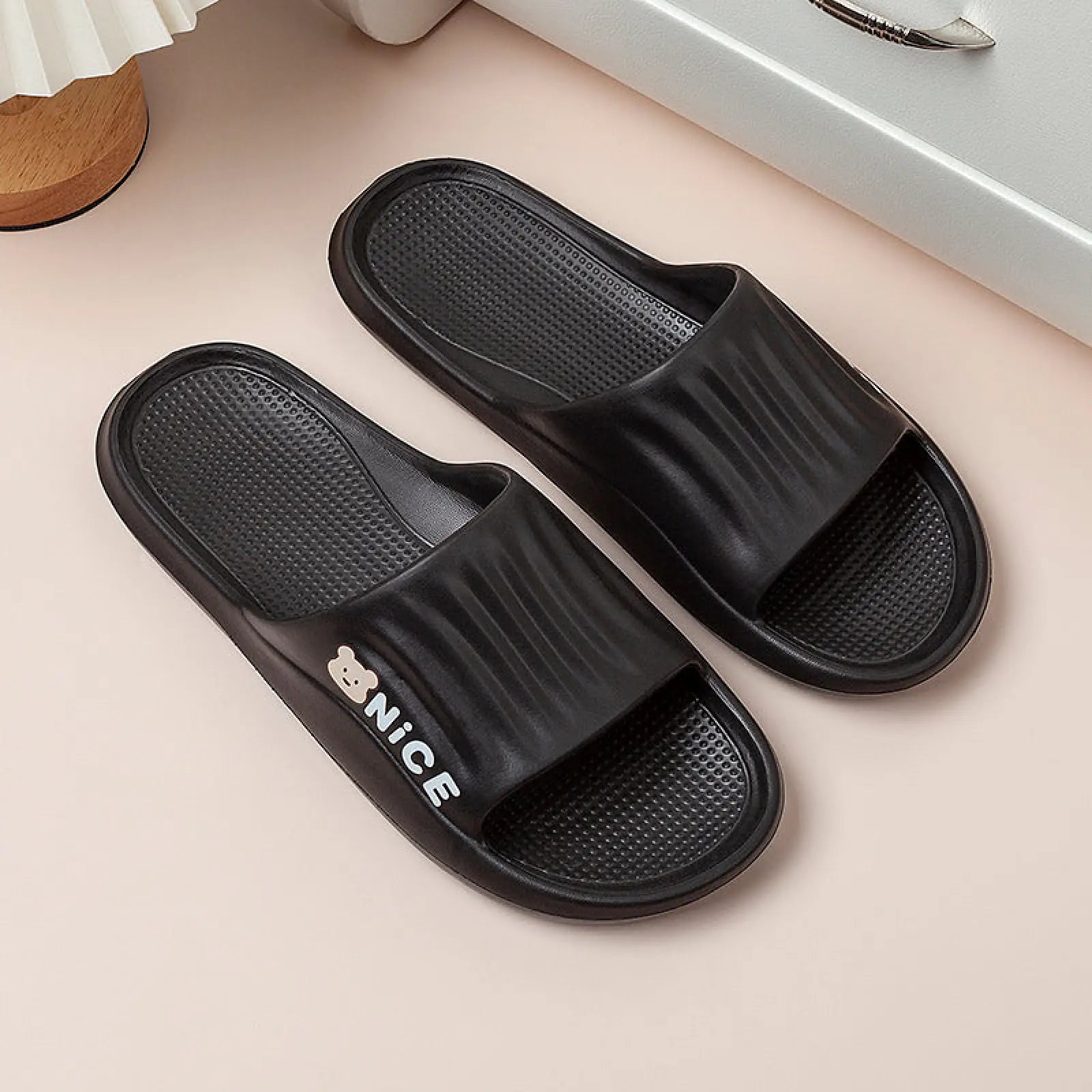 Black rubber unisex lightweight anti slip eva shower slide sandals with textured footbed white nice lettering and bear icon
