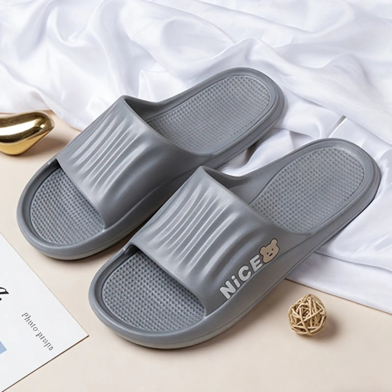 Gray unisex lightweight anti slip eva shower slide sandals with textured sole and nice branding next to a bear logo