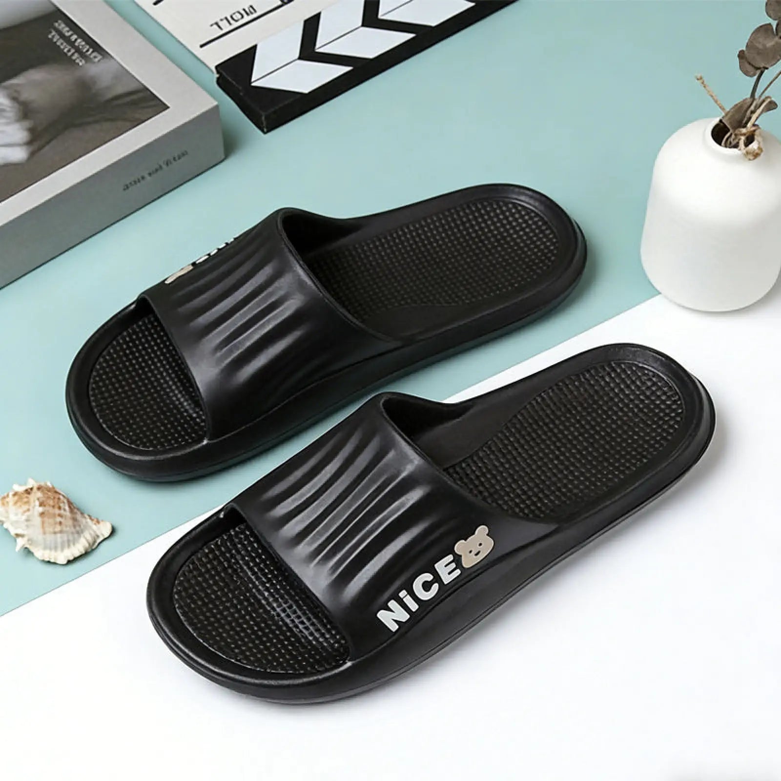 Black rubber unisex lightweight anti slip eva shower slides with textured footbed and nice branding in white lettering