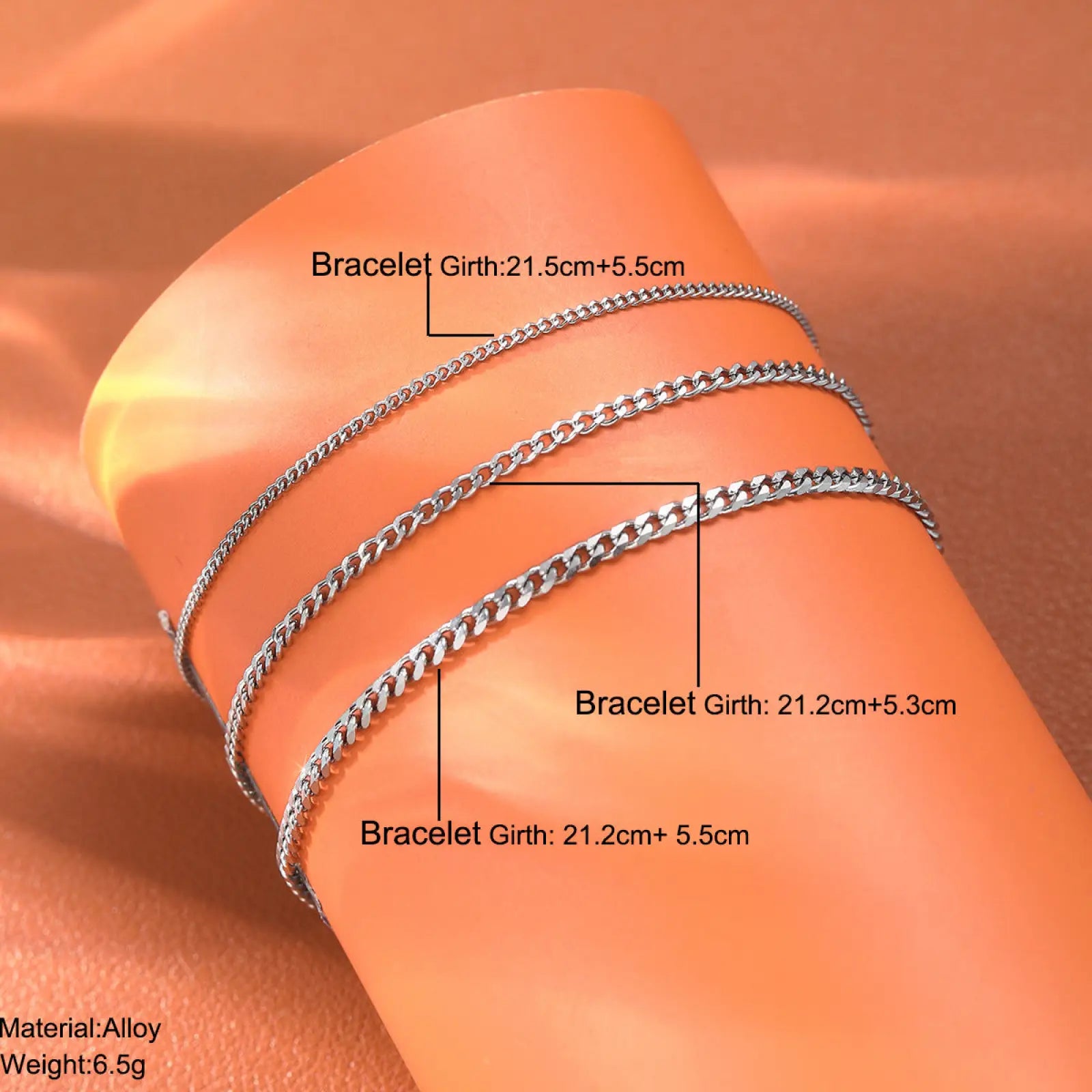 Unisex silver layered Cuban and Figaro link bracelet set featuring three silver-toned chain bracelets on wrist