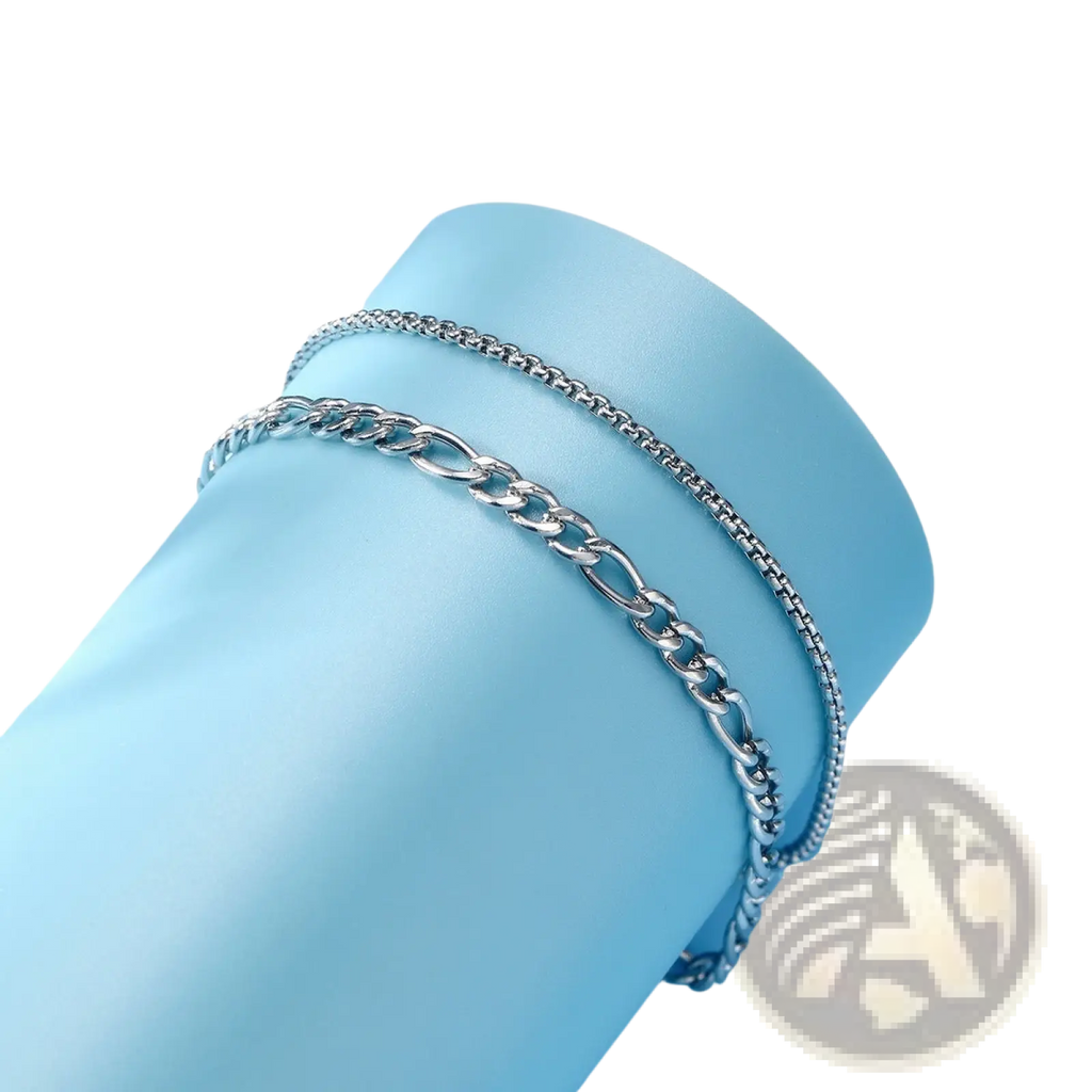 Unisex silver layered Cuban and Figaro link bracelet set featuring a silver-toned stainless steel chain anklet with interlocking links