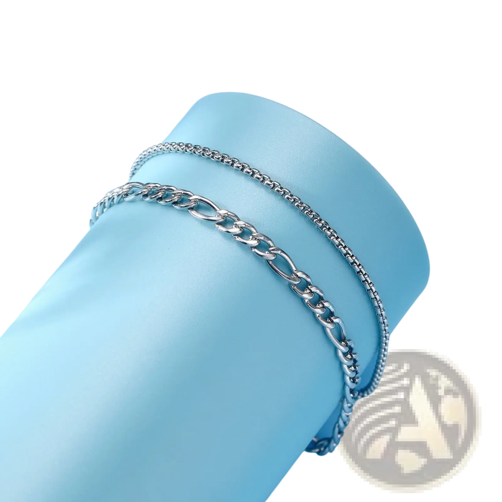 Unisex silver layered cuban and figaro link bracelet set featuring a silver-toned double-layer chain anklet with bold interlocking links and polished finish