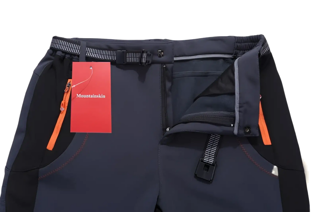 Unisex tactical outdoor hiking pants in dark gray with black side panels orange zipper pulls and contrast stitching