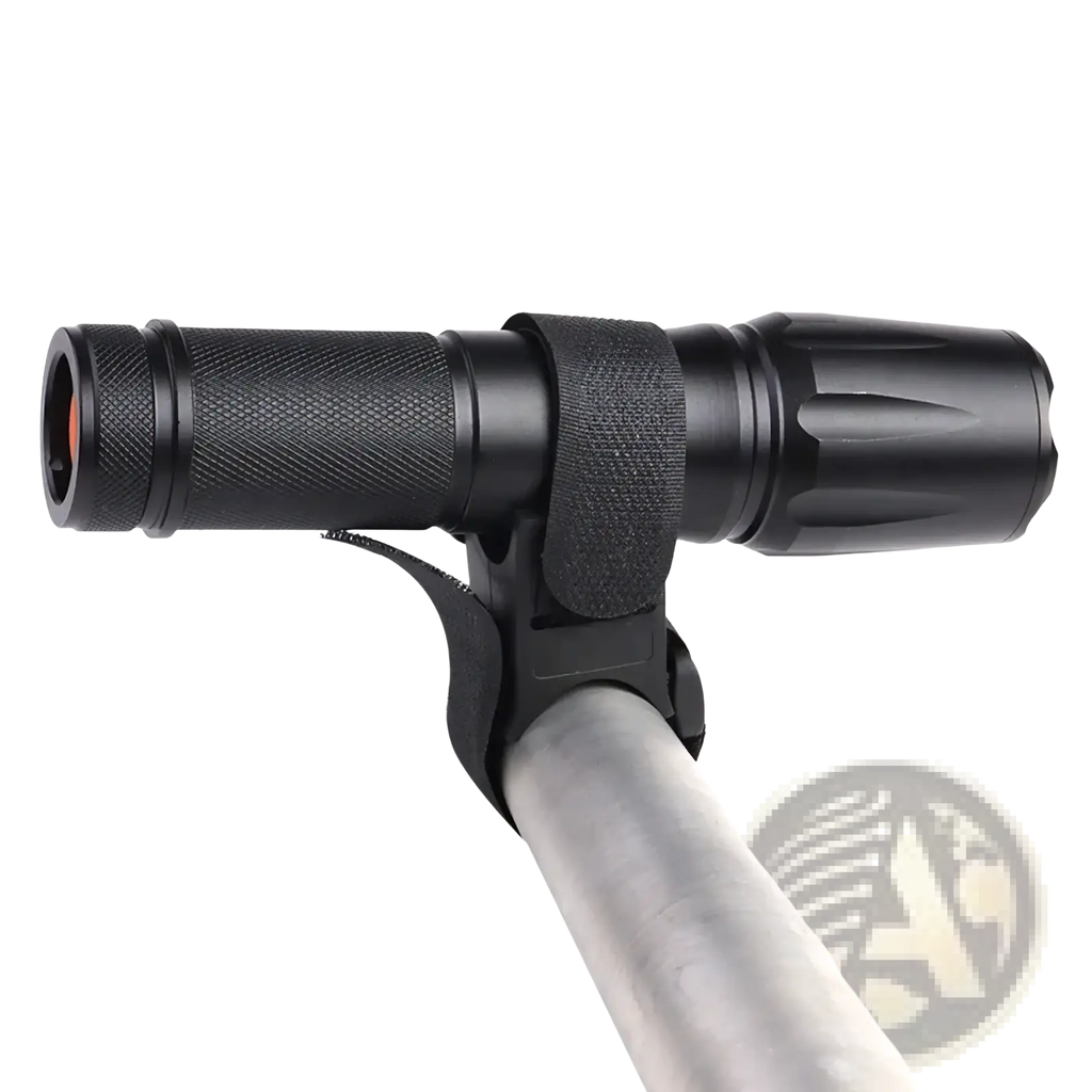Black tactical flashlight with textured grip and adjustable strap mounted on metallic pole using universal bike mount strap holder