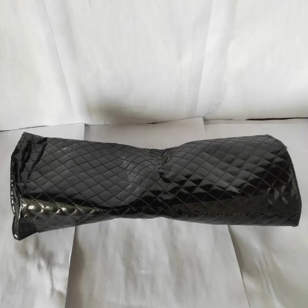 Black quilted patent leather travel case with glossy finish and diamond-patterned stitching for professional cordless hair clipper