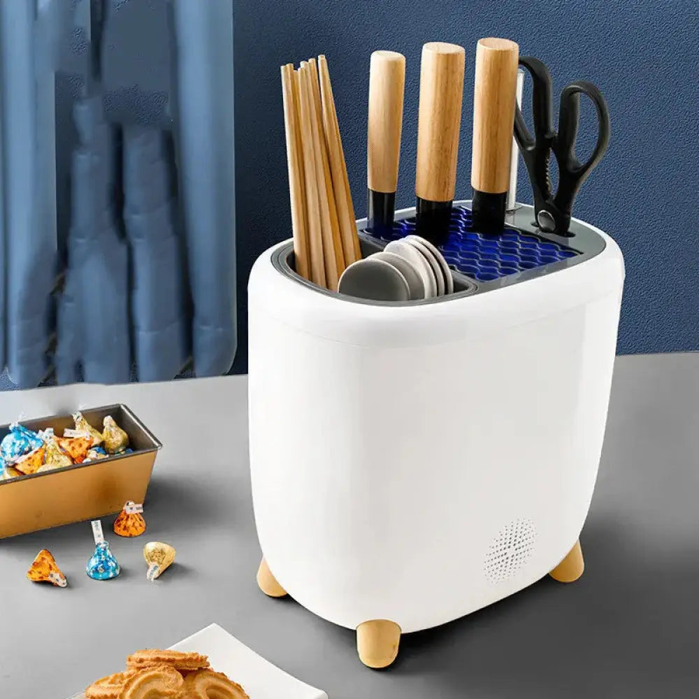 White ceramic 360 rotating cutlery drainer with wooden feet and blue honeycomb insert holding utensils and plates
