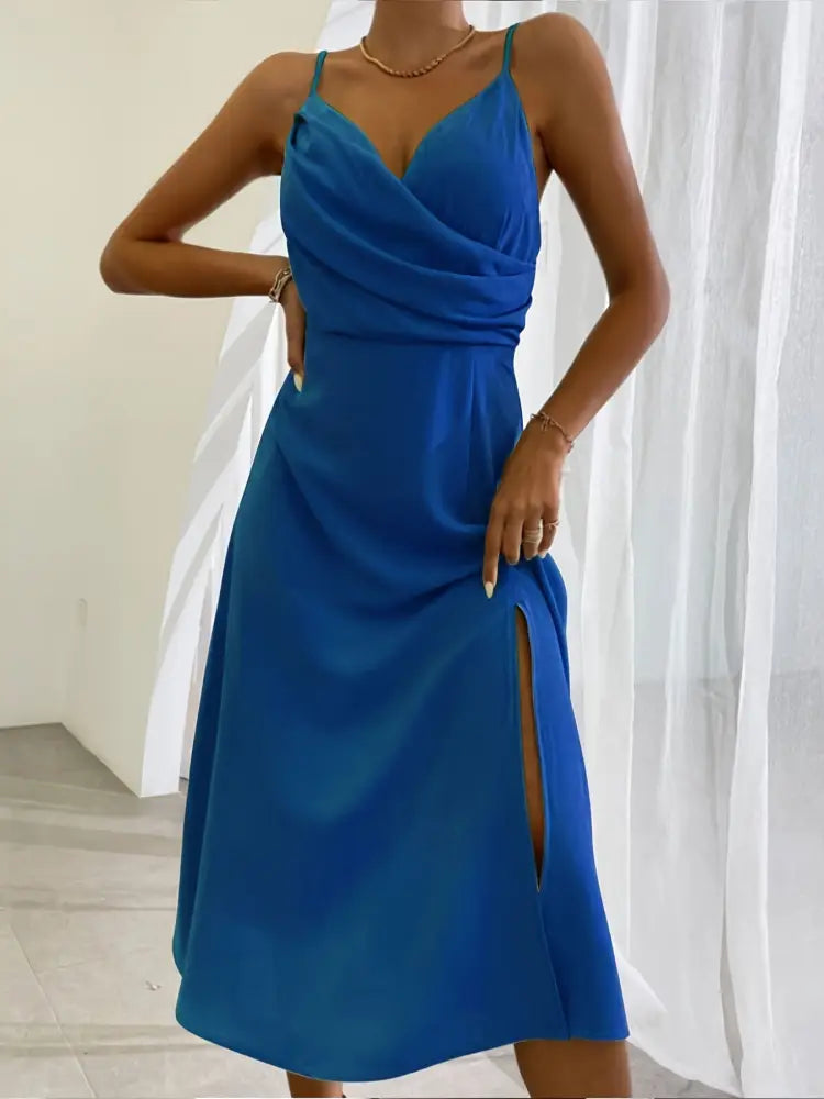 A vibrant royal blue satin v neck summer maxi dress with draped neckline and high side slit