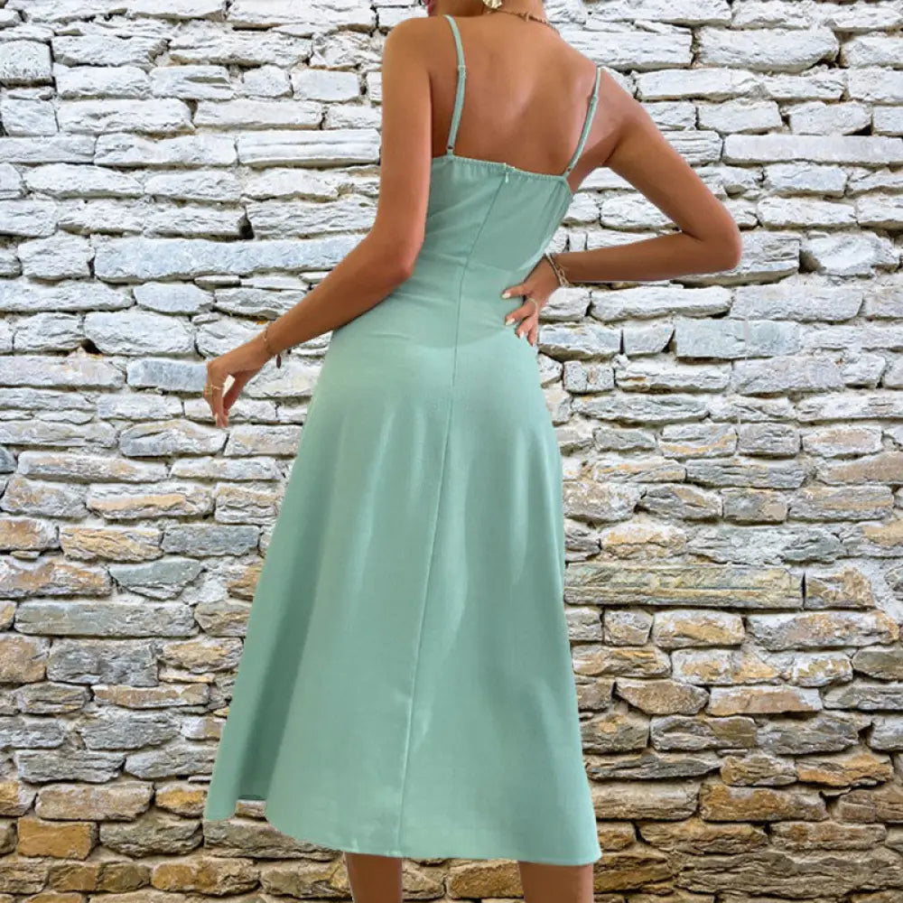 A mint green satin v neck midi dress with thin spaghetti straps and a fitted bodice for summer occasions
