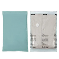 A light teal vacuum bag with a white valve and printed warnings for pump-free large clothes storage vacuum bags