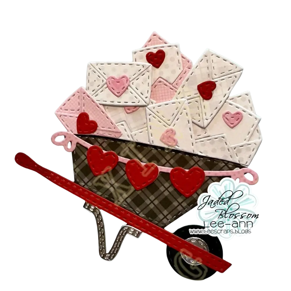 A charming miniature metal wheelbarrow with brown plaid body and red pink hearts from Valentine gnome dies and stamps