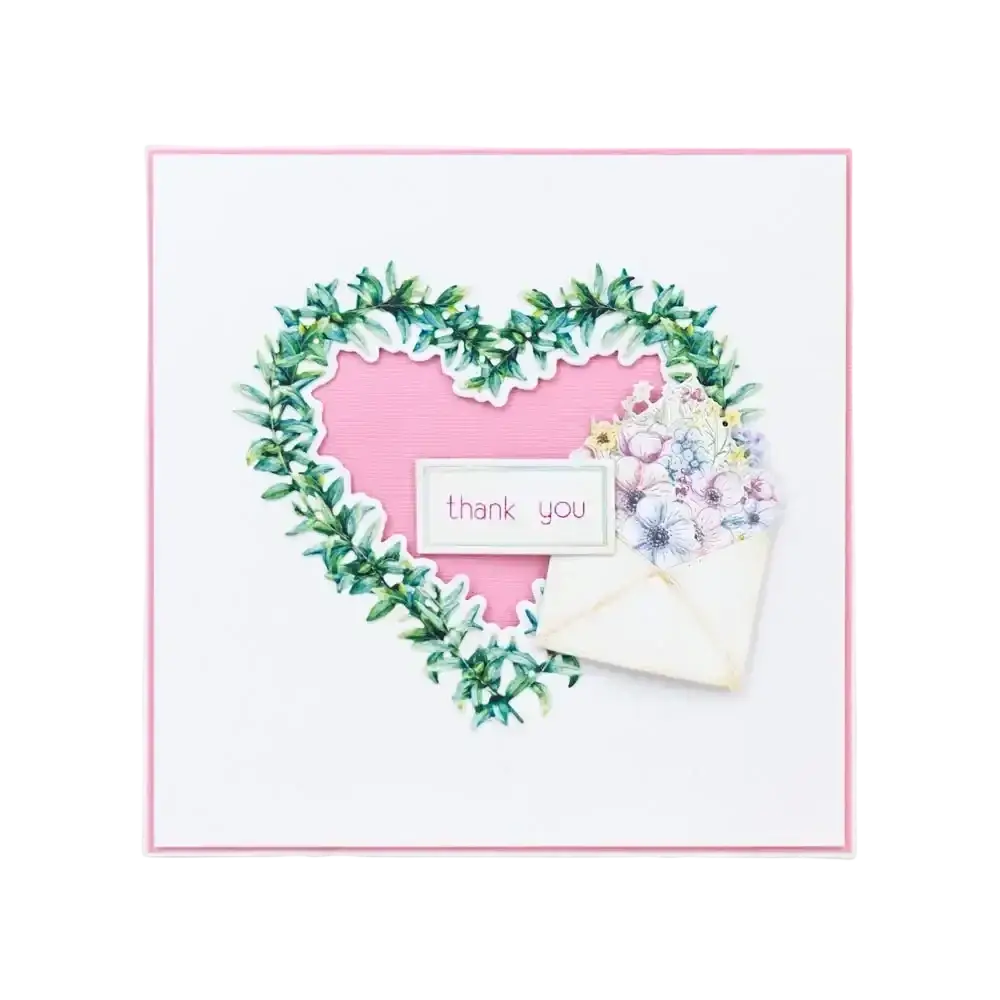 Valentine metal cutting die showing a delicate pink heart card with a green leafy wreath and floral embellishments