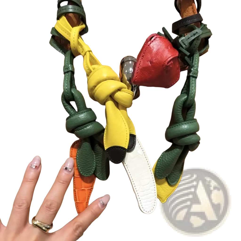 A multicolored leather vegetable handbag charm set featuring a yellow banana with black tips and green leaf accents