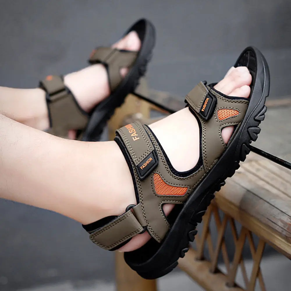 Men’s breathable athletic velcro beach sandals in olive green and black with orange mesh accents on the straps