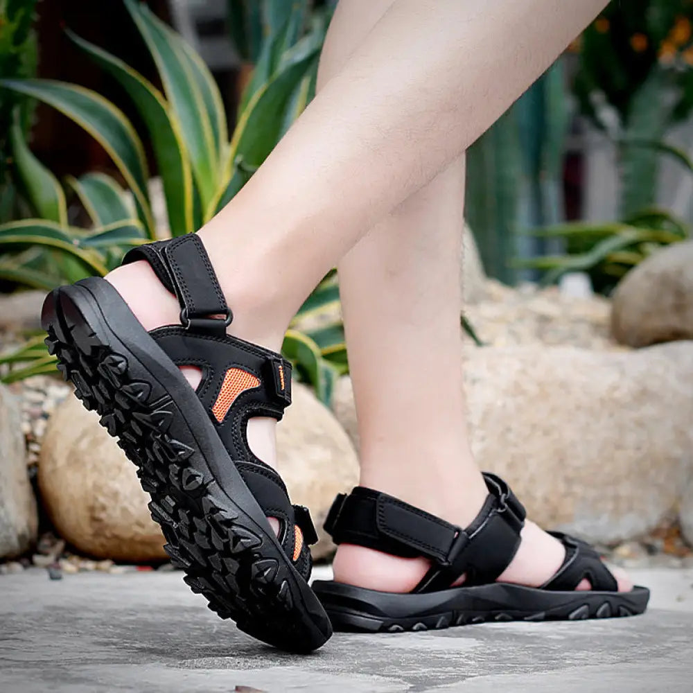 Men’s breathable athletic velcro beach sandals in black and orange with a rugged textured sole for outdoor use