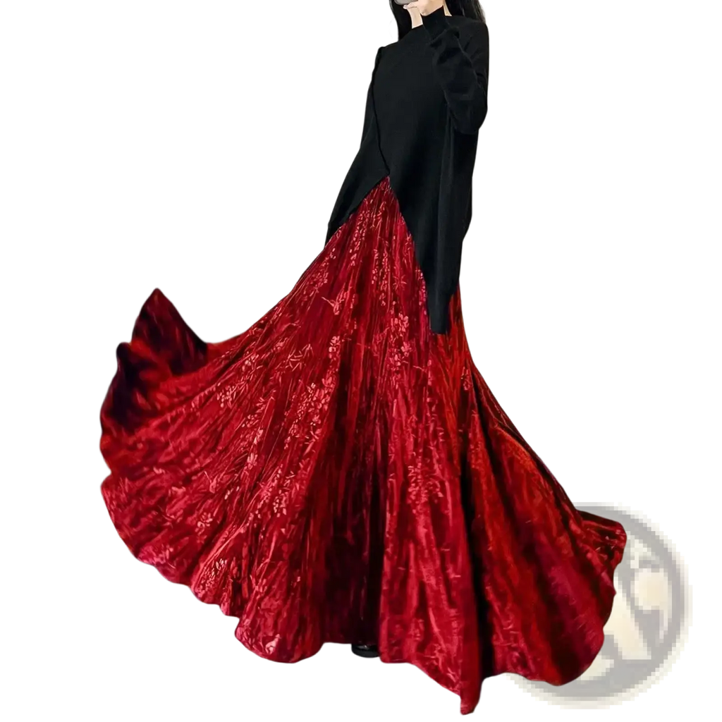A flowing deep red velvet high waist pleated a-line midi skirt with intricate floral embroidery and a high slit