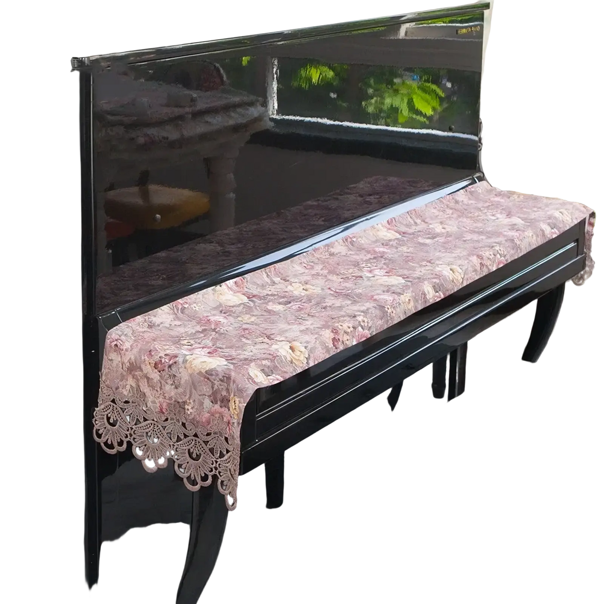 A delicate pink floral lace velvet piano keyboard dust cover with scalloped edges draping over a grand piano
