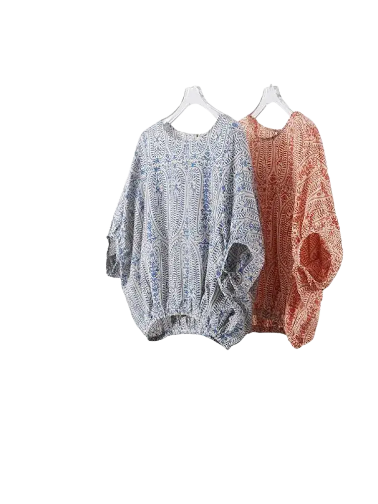 Two vintage bow batwing chiffon blouses with paisley patterns in muted blue white and terracotta orange hang side by side