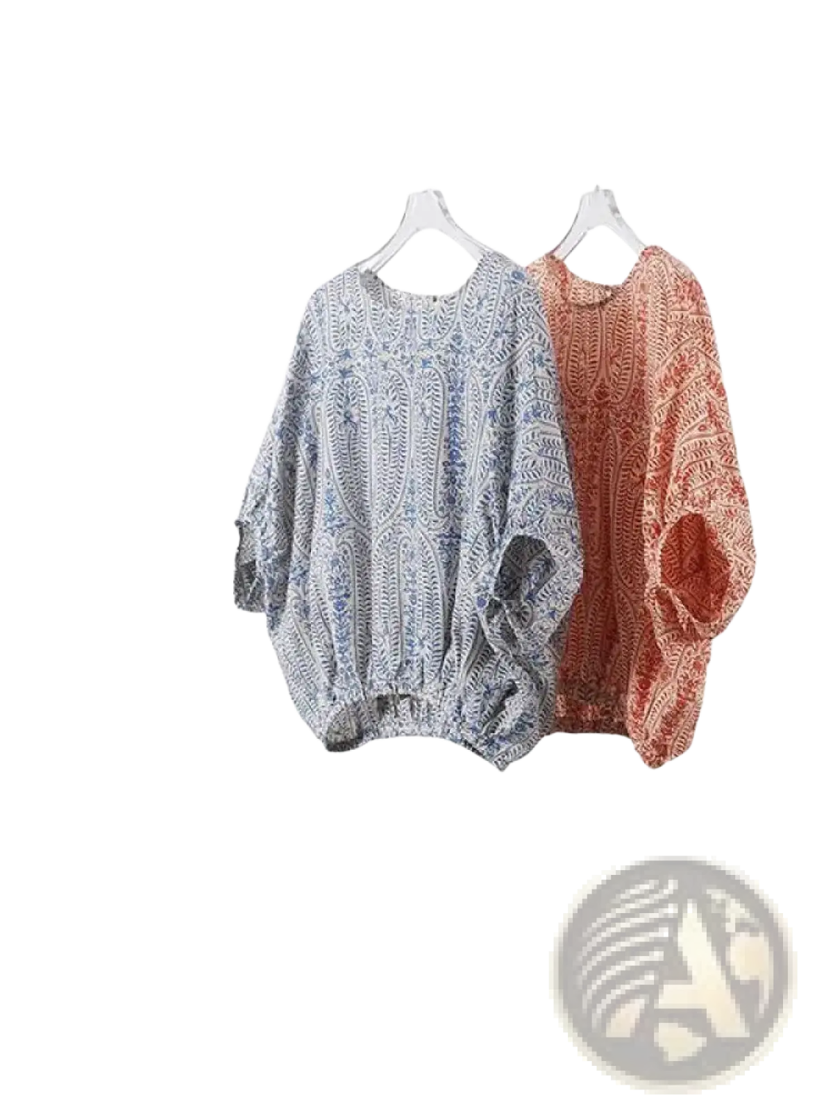 Two vintage bow batwing chiffon blouses with paisley patterns in muted blue white and terracotta orange hang side by side