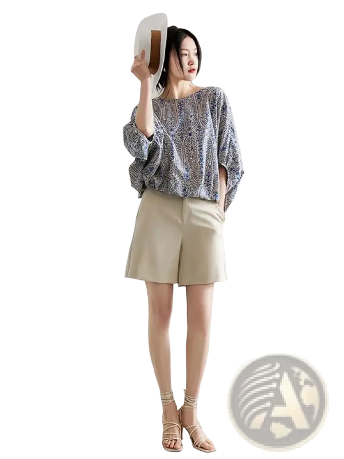 A woman wears a vintage bow batwing chiffon blouse with an intricate blue and white paisley pattern and loose fit