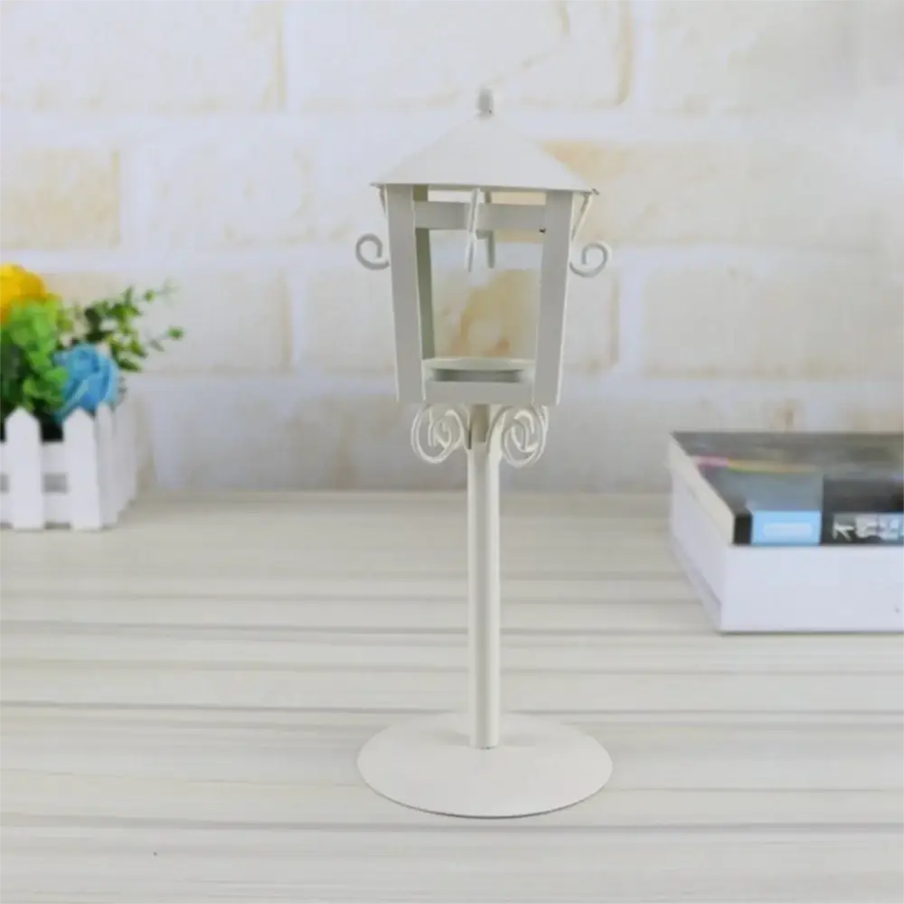 White metal vintage candle holder lantern with ornate scrollwork and flat circular base for vintage candle display