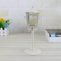 White metal vintage candle holder lantern with ornate scrollwork and flat circular base for vintage candle display