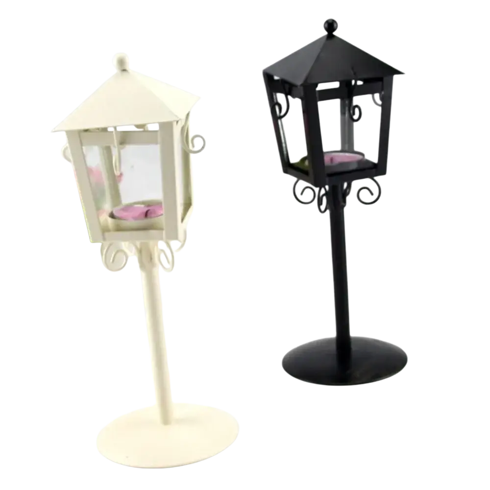 White and black metal vintage candle holders with decorative scrollwork and pink tea light candles in glass panels