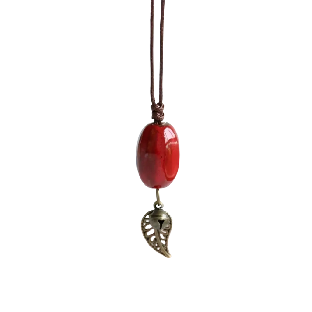 Vintage ceramic leaf pendant necklace for women featuring a glossy red oval bead with bronze leaf charm on brown cord
