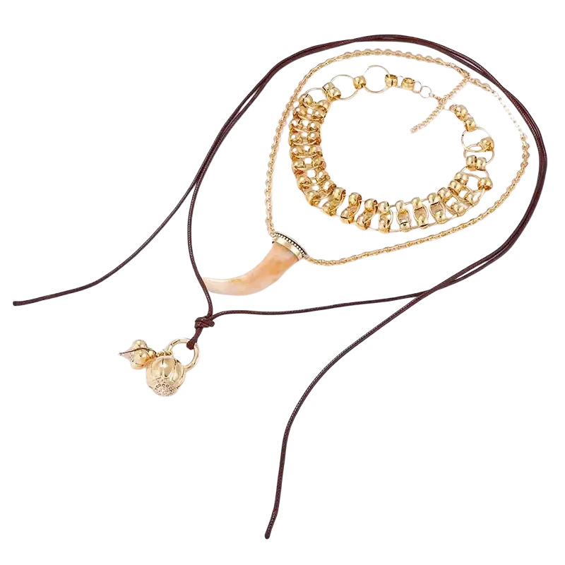 Vintage ethnic layered pendant necklace for women with a bone-like gold-toned pendant on dark brown cord and chain links