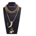Vintage ethnic layered pendant necklace for women in gold tone with ivory tusk pendant and smaller gold charms on bust