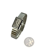 Vintage gold rectangular quartz watch for women with silver metallic band and cream analog face featuring roman numerals