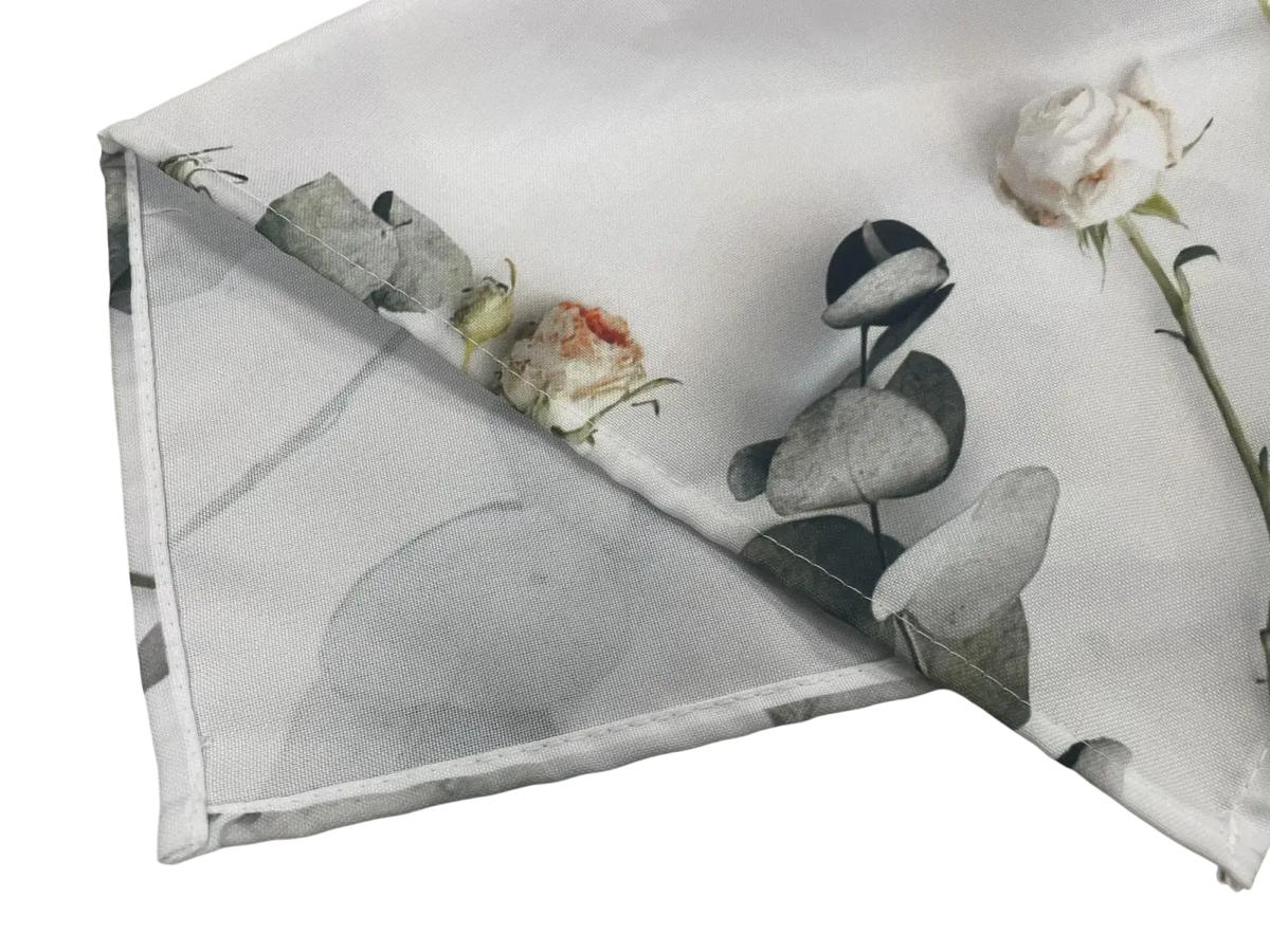 White fabric table runner with muted gray leaves and soft pink roses floral print in rustic farmhouse style