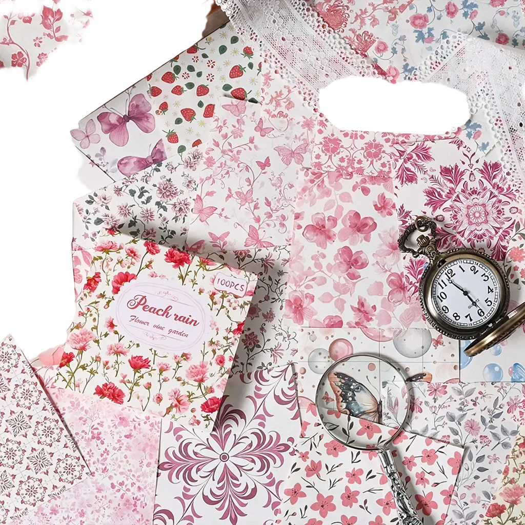 A delicate pink floral vintage scrapbooking paper pack labeled peach rain with a pocket watch and magnifying glass nearby