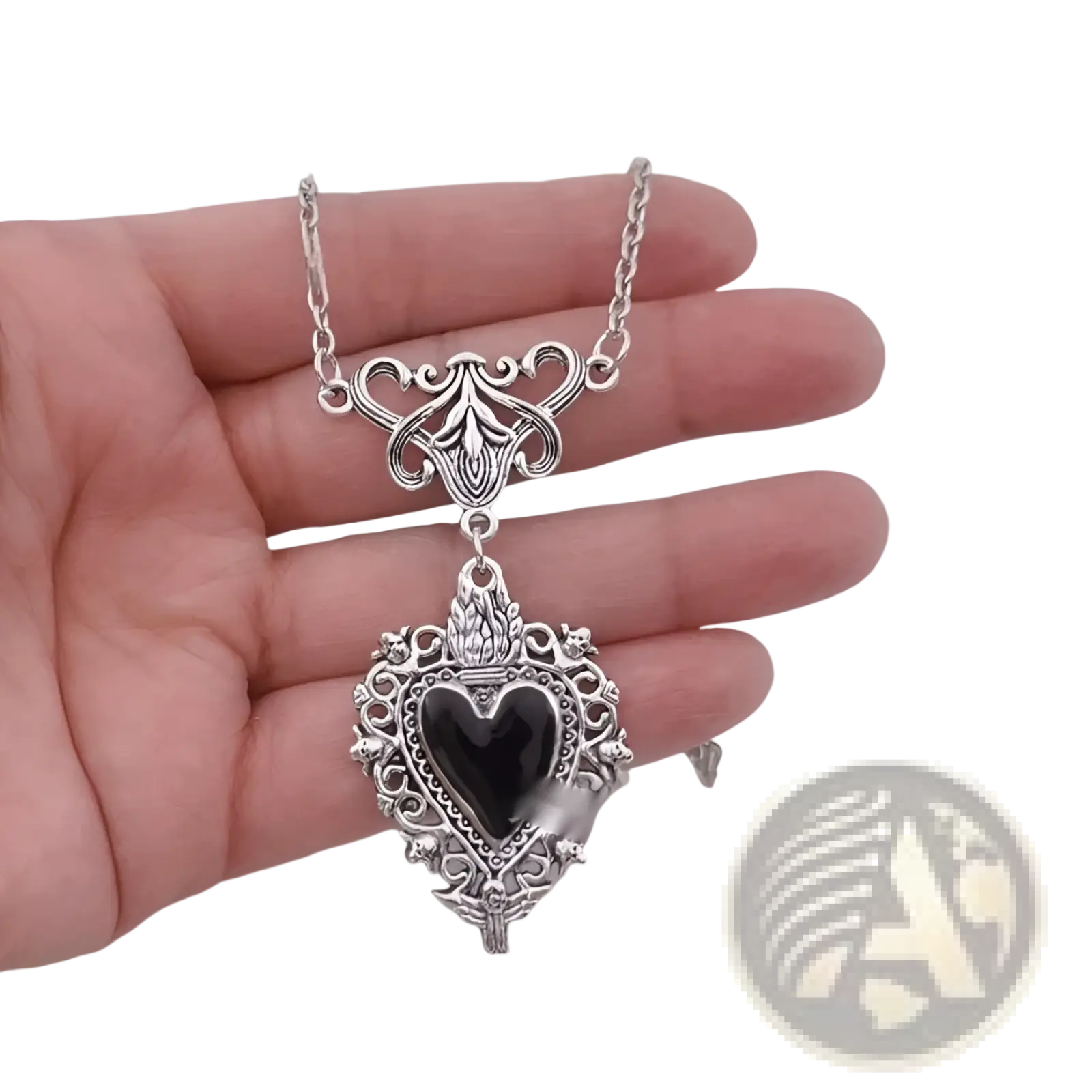 Silver heart-shaped pendant necklace with intricate filigree detailing and a black onyx center gemstone