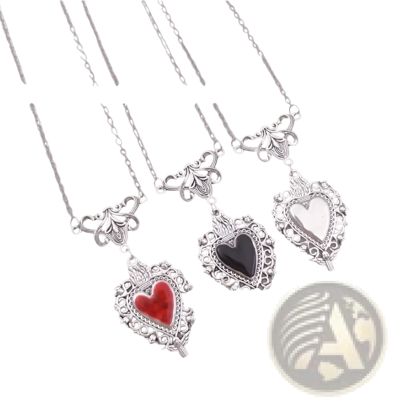 Vintage silver filigree heart pendant with intricate detailing and a central red enamel gemstone in an ornate frame