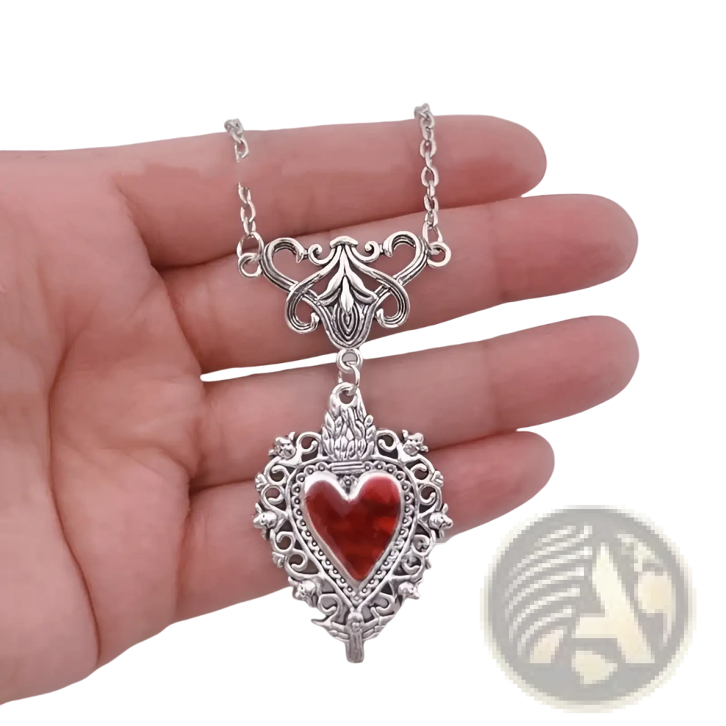 Vintage silver filigree heart pendant necklace with vibrant red enamel center and ornate vintage-inspired detailing