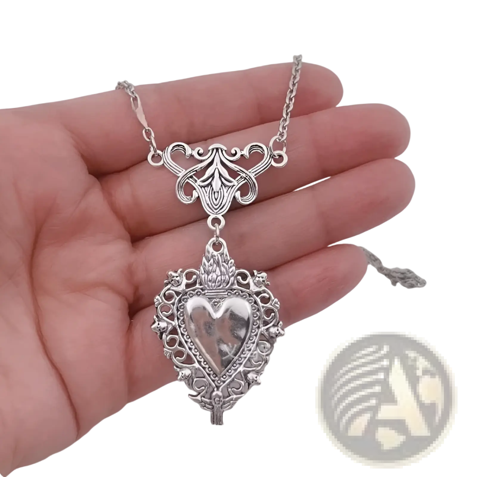 Vintage silver filigree heart pendant necklace with intricate detailing and decorative chain featuring red enamel center