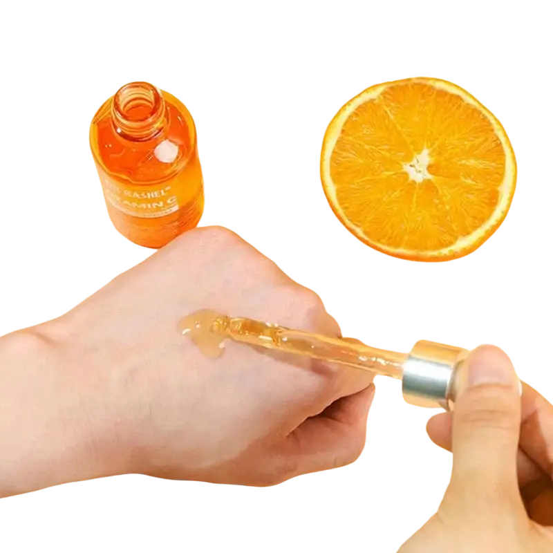 Orange-colored glass dropper bottle with silver cap containing clear liquid in vitamin c brightening skincare set