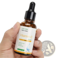 A 30ml amber glass bottle of Isner Mille vitamin C serum with black dropper and white label with gold accents