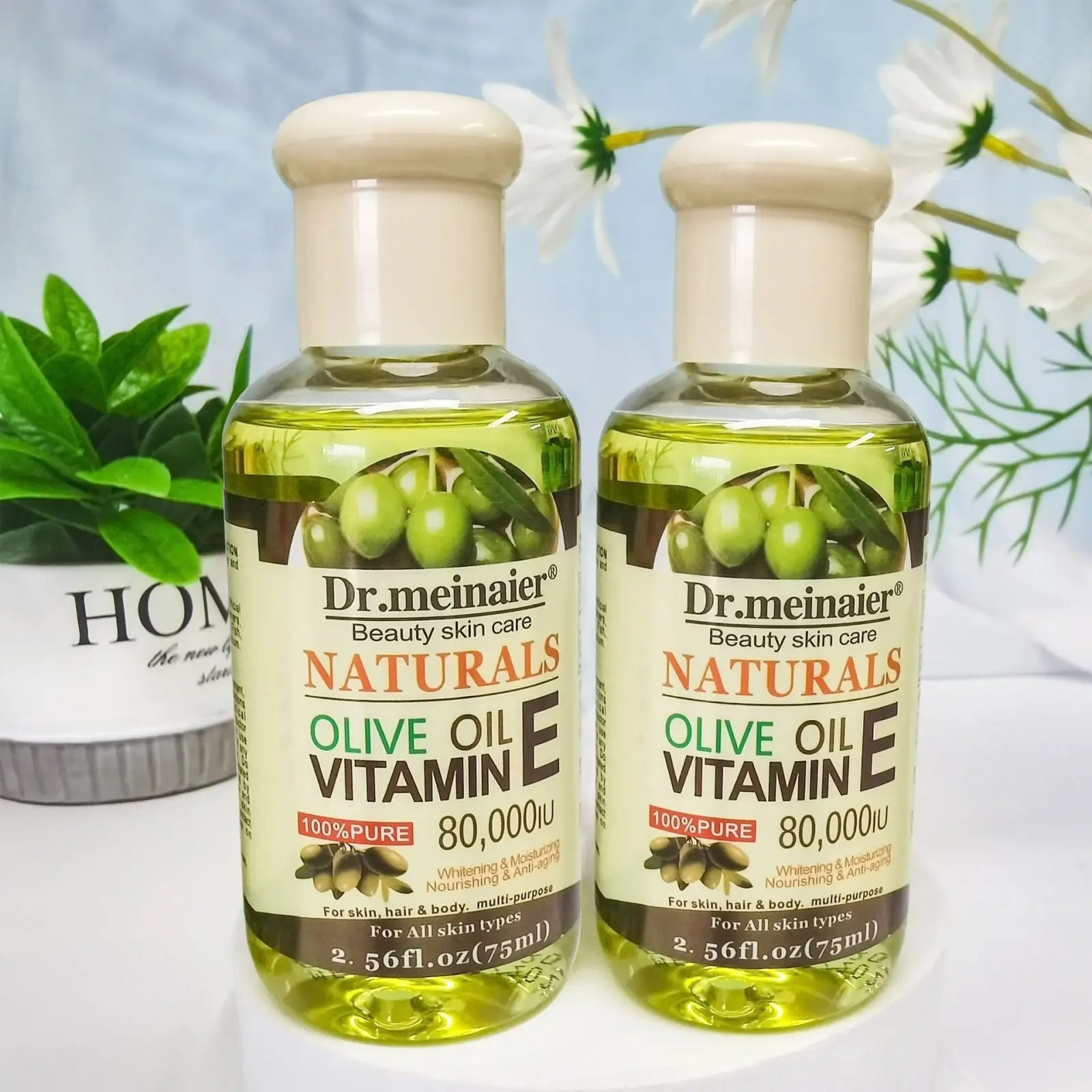Two clear glass bottles of dr vitamin e synthesis oil for face body and hair 75ml shown from the front side