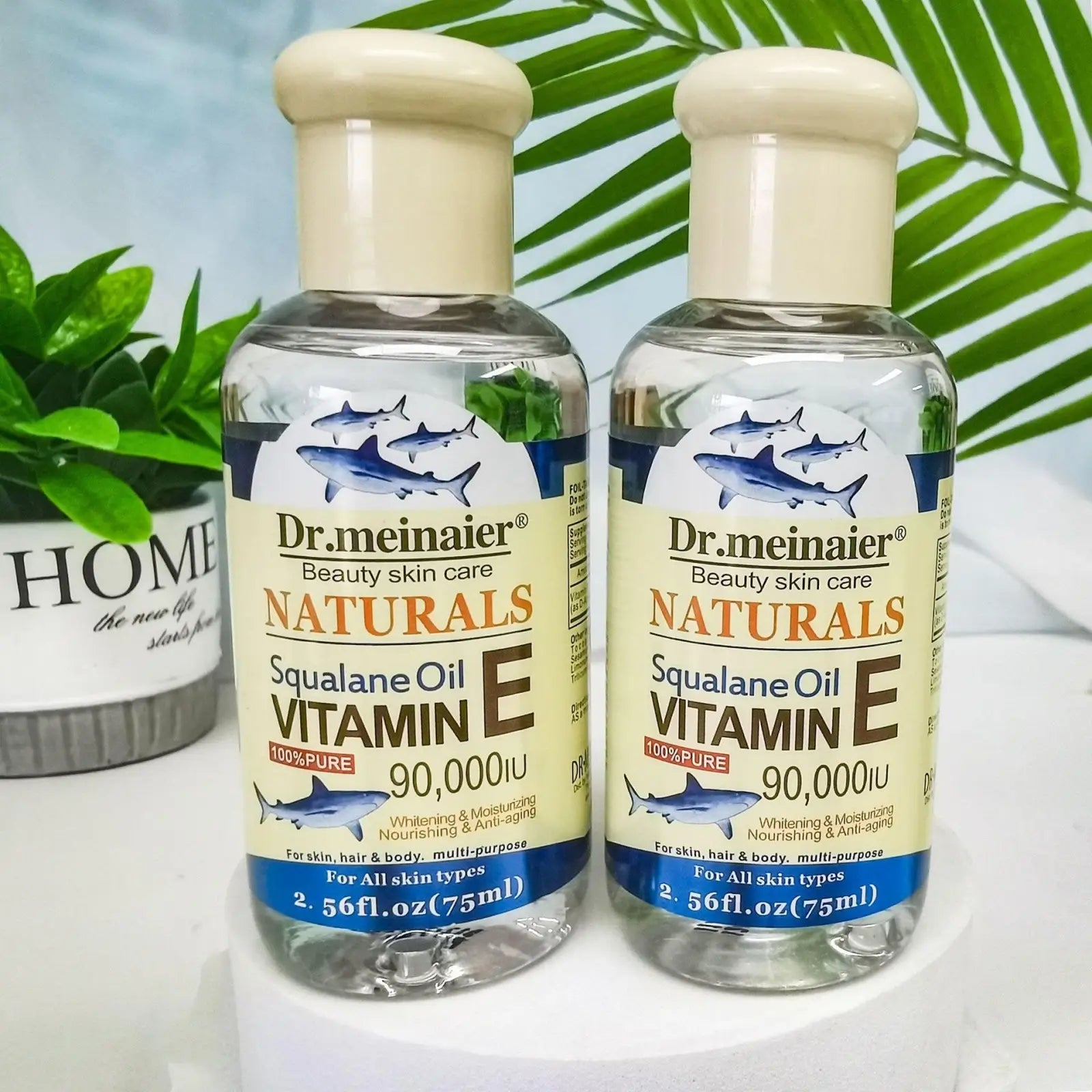 Two clear glass bottles of dr vitamin e synthesis oil for face body and hair 75ml with transparent labels